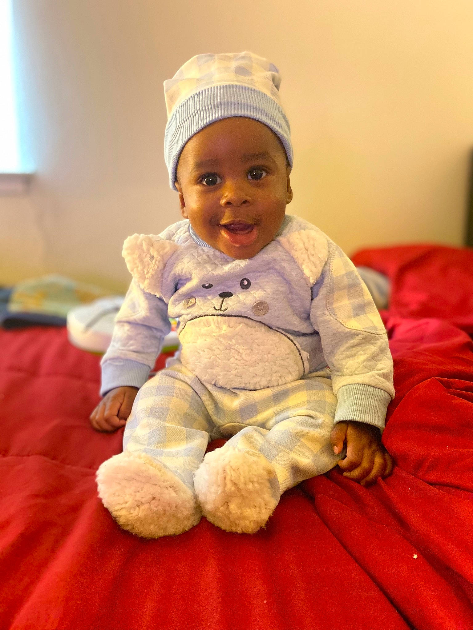 Lawrence is registered to the contest to win money with this photo: baby, baby_toddler_clothing, cap, cheek, child, chin, comfort, eye, flooring, fun, happy, head, human_leg, knee, person, sitting, skin, sleeve, smile, toddler