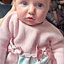 baby, child, infant, pink_sweater, bows, knitted_clothing, dress, pastel_colors, blue_eyes, hand, portrait, indoor, soft_light, curious_expression, closeup, cute, person, newborn, seat, fabric