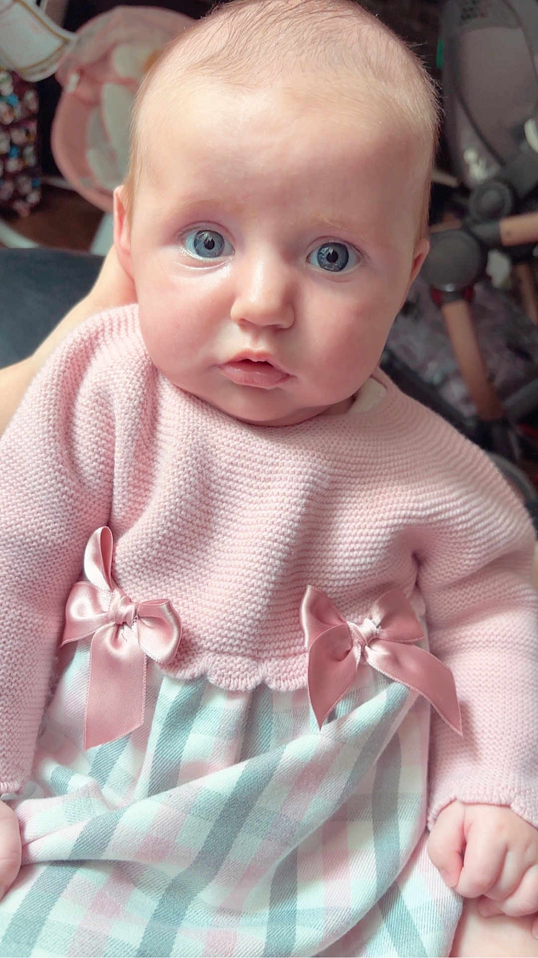 Isabella joined the competition — help win amazing prizes! baby, child, infant, pink_sweater, bows, knitted_clothing, dress, pastel_colors, blue_eyes, hand, portrait, indoor, soft_light, curious_expression, closeup, cute, person, newborn, seat, fabric