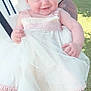 Isabella is registered to the contest to win money with this photo: baby, child, smile, dress, white_dress, lace, outdoor, sunlight, grass, person, holding, cute, happy, footwear, socks, garden, portrait, infant, young_child, human