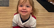 Kimber is registered to the contest to win money with this photo: candid, casual, child, clothing, cute, door, floor, hair_tuft, happy, indoor, long_sleeves, person, playful, room, shelves, smiling, sweater, toddler, wooden_floor, young_child