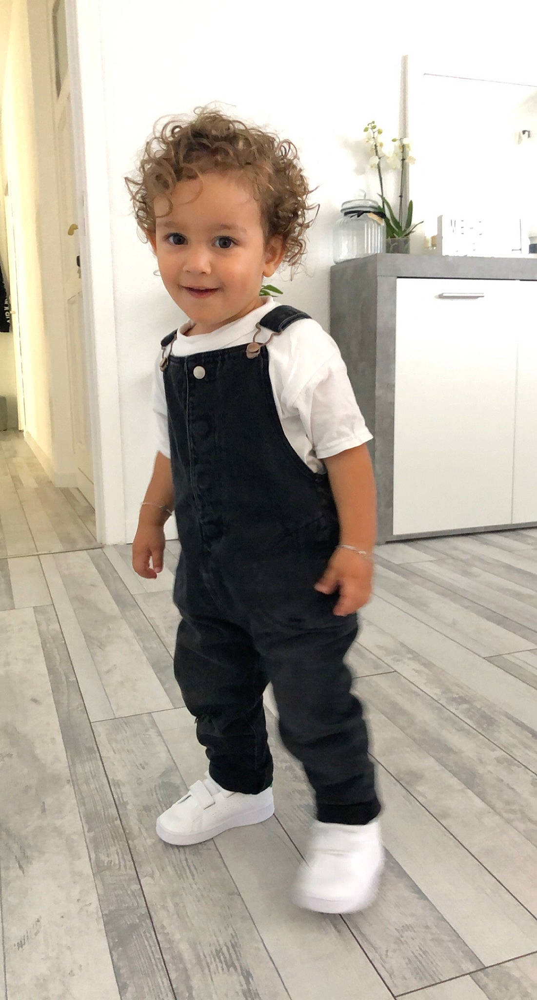 Meyssan participe au concours pour gagner de l'argent avec cette photo : active_pants, baby, baby_toddler_clothing, face, flooring, formal_wear, fun, happy, hardwood, houseplant, joint, joy, knee, leg, outerwear, person, shoe, sleeve, smile, toddler