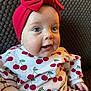 Elodie joined the competition — help win amazing prizes! baby, child, headband, red_bow, blue_eyes, cherry_pattern, white_outfit, clothing, cute, infant, portrait, sitting, hand, face, happy, indoors, texture, cushion, cozy, smiling