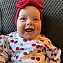 baby, child, smiling, headband, red_bow, cherry_pattern, shirt, happy, face, blue_eyes, infant, cute, portrait, sitting, indoors, closeup, skin, cheeks, clothing, texture