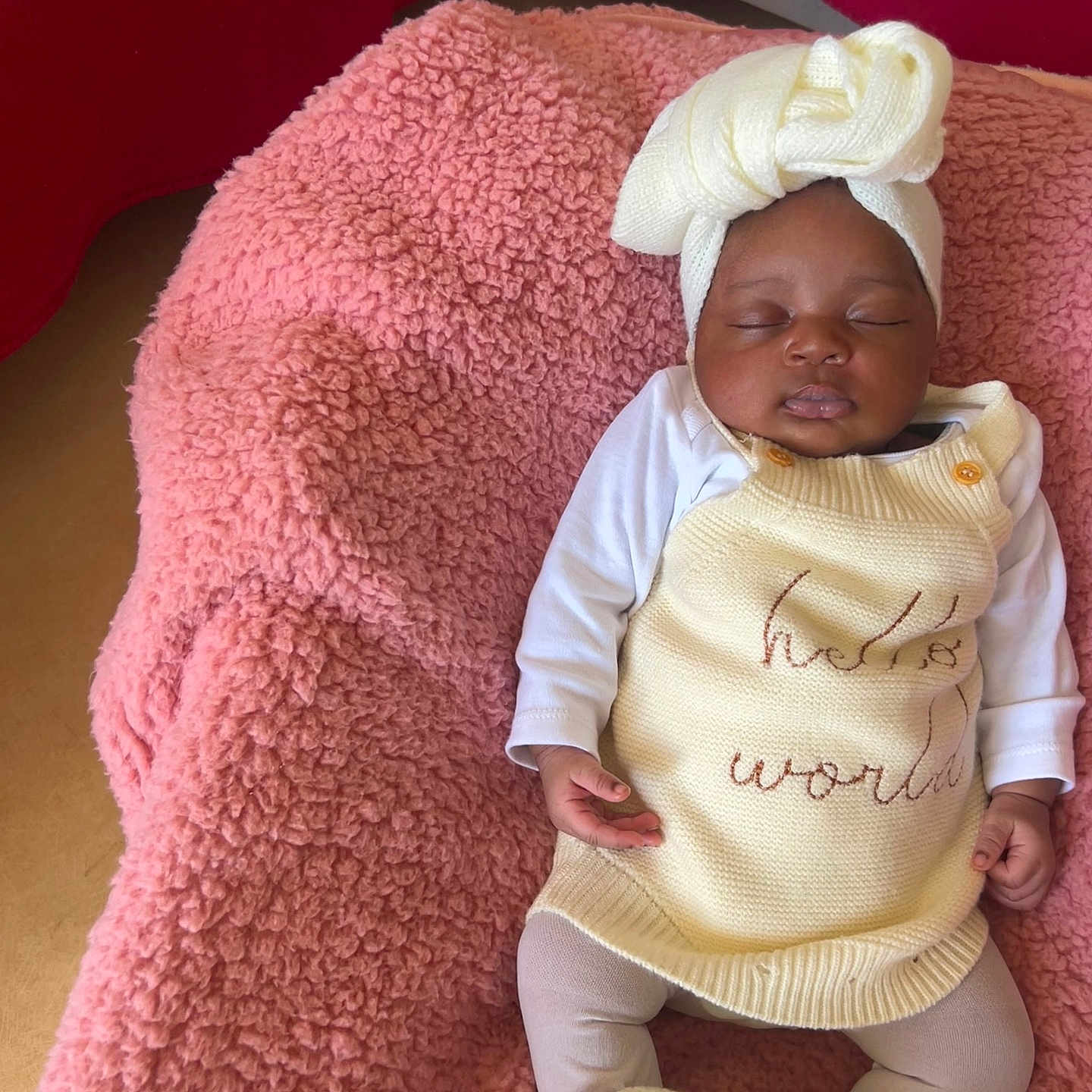 Iris a rejoint le concours — aidez-le/la à gagner de superbes lots ! baby, sleeping, infant, knitwear, headwrap, blanket, pink, red, cozy, cute, child, soft_texture, resting, clothing, footwear, indoors, portrait, peaceful, small_hands, newborn