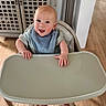 Austen joined the competition — help win amazing prizes! baby, high_chair, smiling, indoor, wooden_floor, bib, happy, infant, face, person, cabinet, footrest, hands, home, furniture, cute, child, young, portrait, light