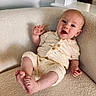 baby, infant, child, knitted_clothing, armchair, cozy, smile, happy, portrait, indoor, cute, comfort, furniture, relaxing, expression, skin, head, feet, hand, button