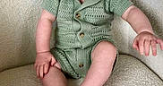 Austen is registered to the contest to win money with this photo: baby, child, smiling, green_clothing, knitted_outfit, armchair, indoor, happy, cute, infant, person, sitting, portrait, furniture, cozy, barefoot, young_child, skin, head, expression