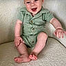 baby, child, smiling, green_clothing, knitted_outfit, armchair, indoor, happy, cute, infant, person, sitting, portrait, furniture, cozy, barefoot, young_child, skin, head, expression