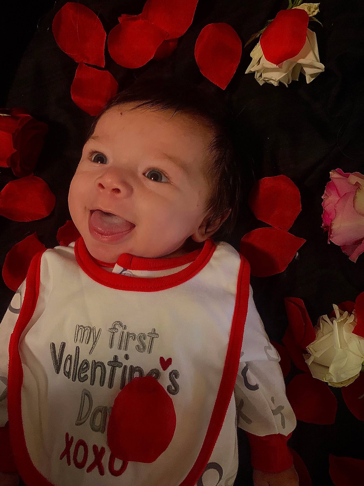 Hudson is registered to the contest to win money with this photo: baby, baby_toddler_clothing, cheek, chin, face, happy, head, lip, outerwear, person, petal, pink, plant, product, red, skin, sleeve, smile, textile, toddler