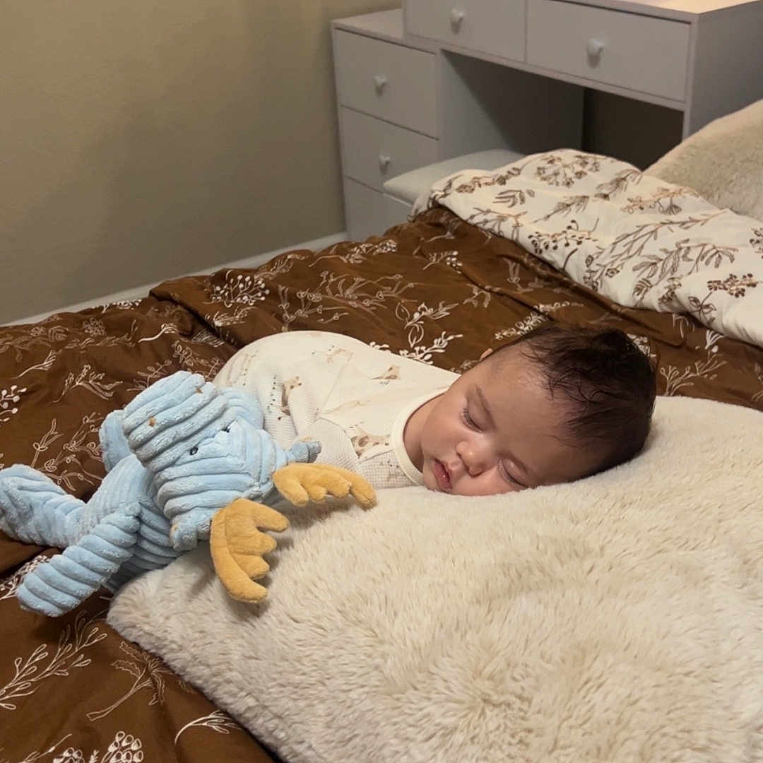 Soren is registered to the contest to win money with this photo: baby, beauty_products, bed, blanket, brown, child, cozy, cream, cute, furniture, indoors, mirror, nursery, peaceful, pillow, plush_toy, skincare, sleeping, soft, vanity