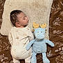 Soren is registered to the contest to win money with this photo: baby, sleeping, pillow, plush_toy, moose, blue, yellow_antlers, onesie, animal_print, bedspread, brown, floral_pattern, soft_texture, cozy, infant, child, cute, indoors, resting, peaceful