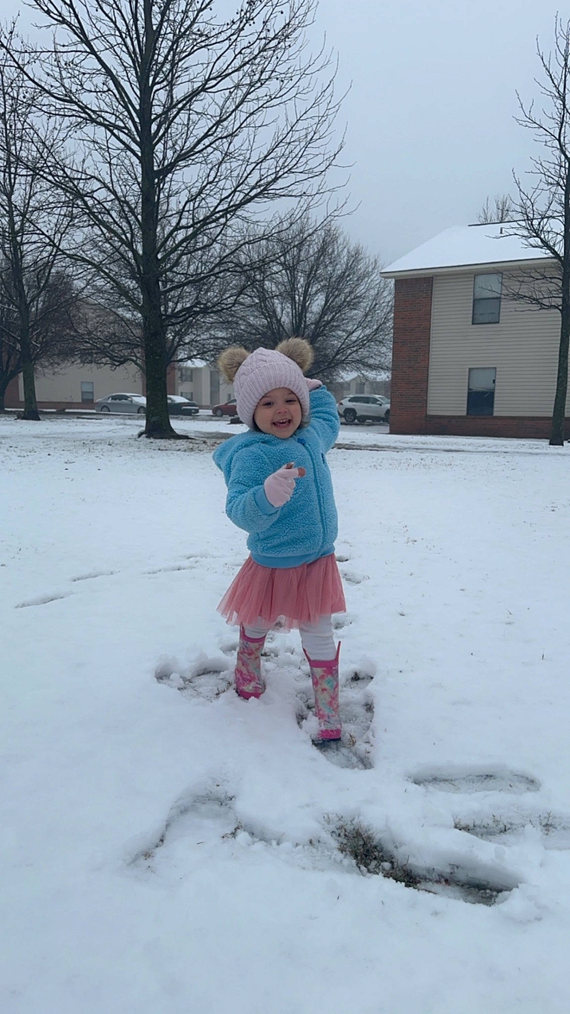 Aliyanna is registered to the contest to win money with this photo: building, child, electric_blue, event, freezing, frost, fun, hat, headwear, house, joy, people_in_nature, person, play, playing_in_the_snow, precipitation, recreation, sky, snow, toddler
