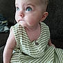 Ellie is registered to the contest to win money with this photo: baby, child, blue_eyes, striped_clothing, sitting, couch, indoor, curious, face, head, arm, skin, infant, young_child, portrait, person, clothing, button, closeup, expression