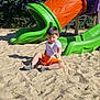 casual_clothing, child, daylight, footwear, fun, greenery, kid, nature, orange_shorts, outdoor, park, playground, playing, recreation, sand, slide, summer, sunlight, trees, white_tshirt
