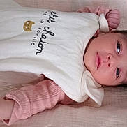 Aya joined the competition — help win amazing prizes! baby, newborn, infant, face, hand, pink_clothing, white_bib, cat_design, text, blanket, lying_down, portrait, cute, soft_texture, sleepwear, child, young, resting, indoors, peaceful