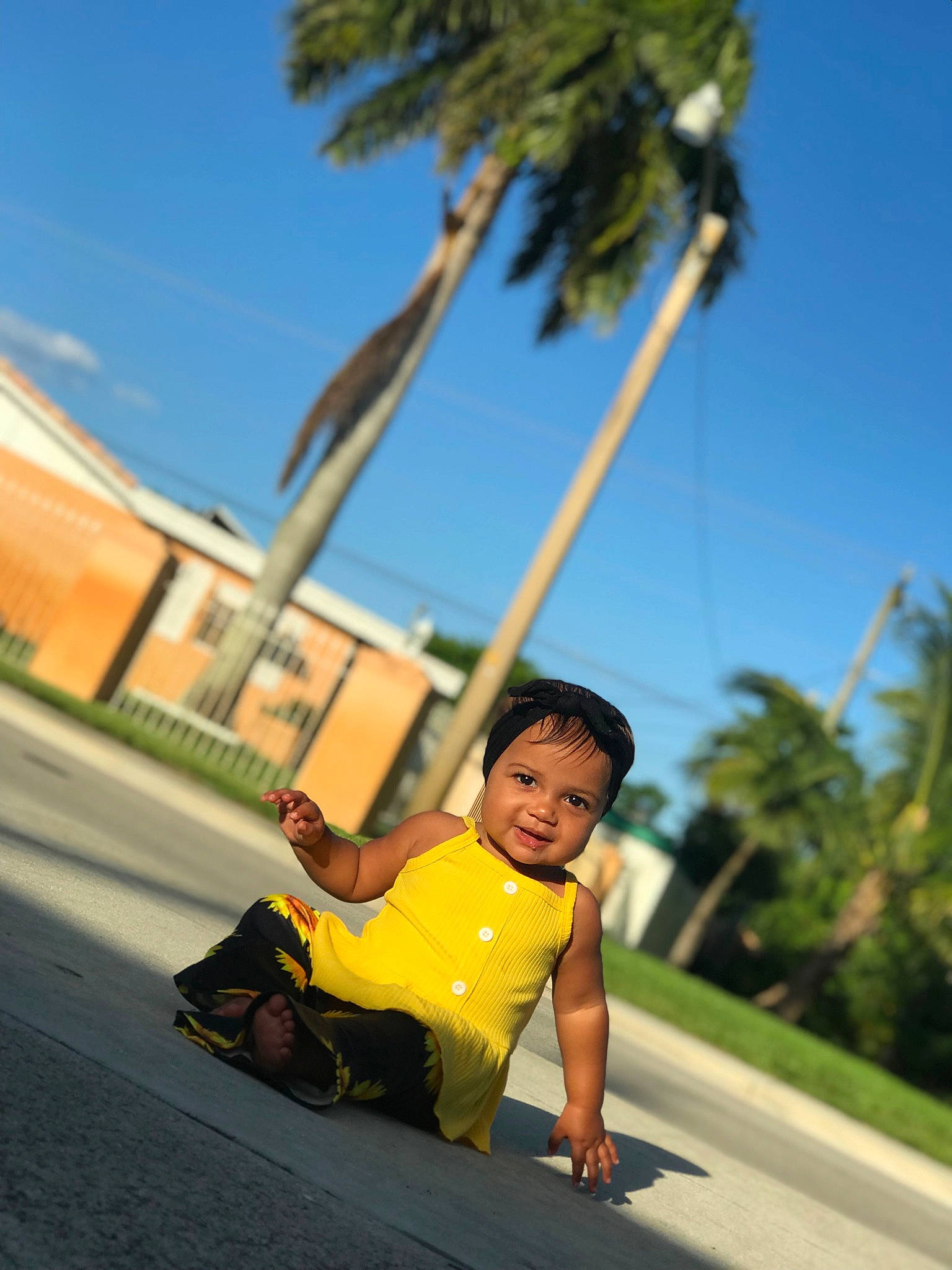 Kennaleigha is registered to the contest to win money with this photo: arecales, asphalt, city, fun, grass, happy, headwear, landscape, leisure, palm_tree, person, plant, recreation, road, road_surface, rolling, sidewalk, sky, summer, toddler