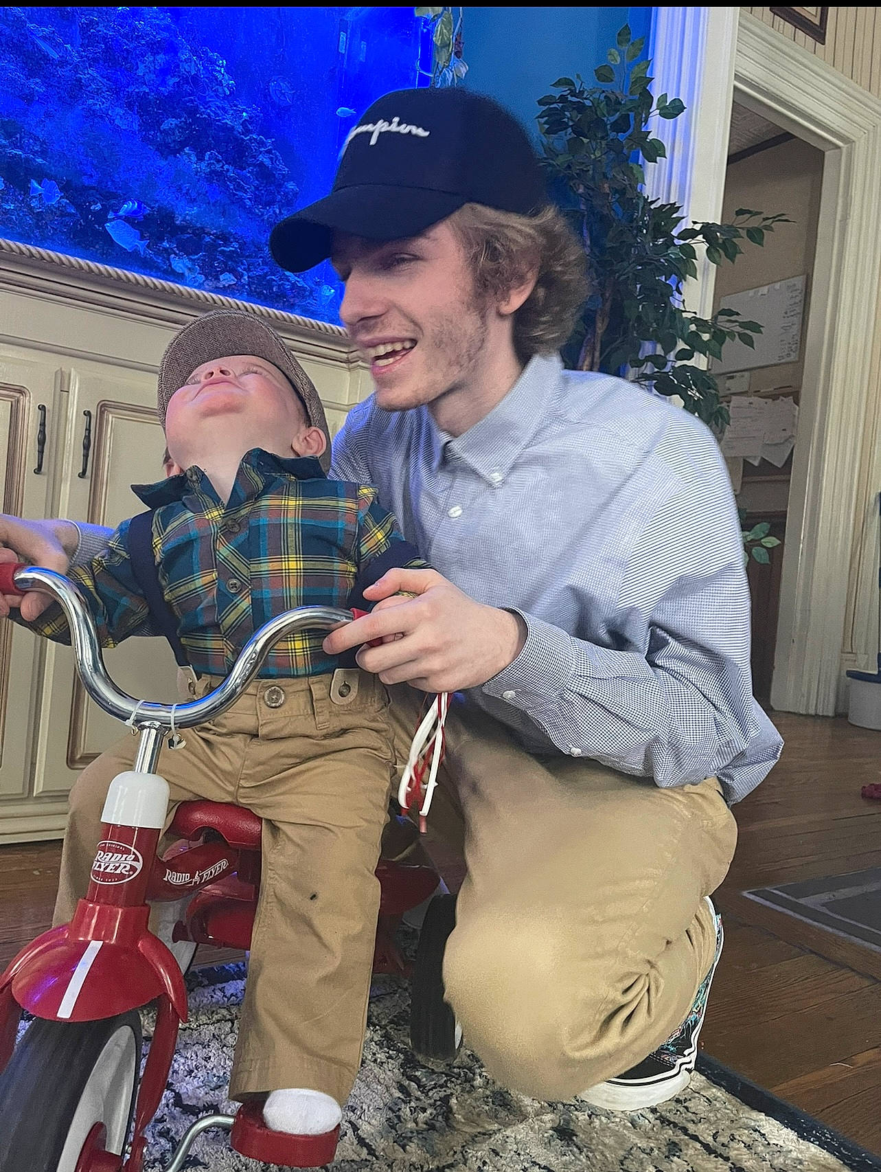 Jaxson is registered to the contest to win money with this photo: baseball_cap, bicycle_saddle, bicycle_wheel, cap, child, cool, curtain, fun, grass, happy, hat, headwear, joy, leisure, motor_vehicle, motorcycle, person, plant, smile, tire