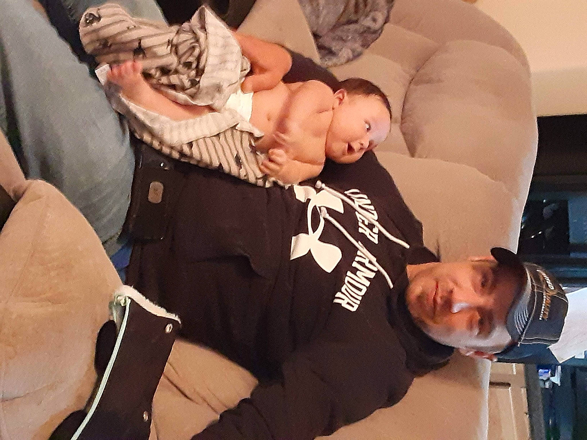 Zealand is registered to the contest to win money with this photo: abdomen, baby, child, comfort, elbow, event, eyewear, fashion_accessory, font, fun, gesture, happy, hat, headwear, jewellery, nail, person, room, sitting, thumb