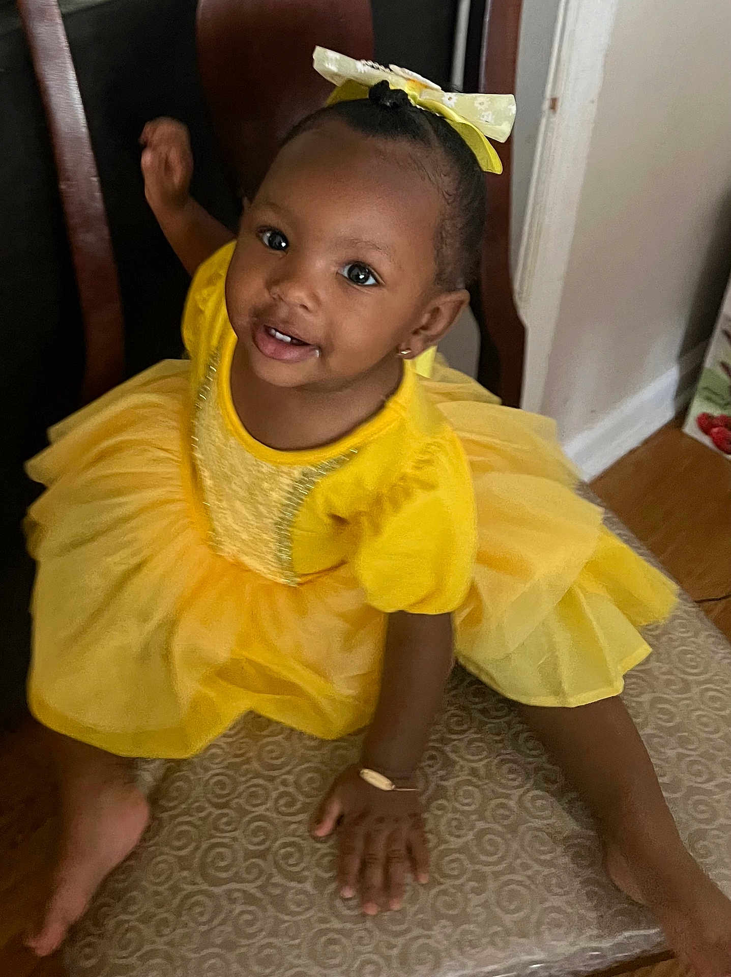 Emora Belle joined the competition — help win amazing prizes! toddler, child, yellow_dress, bow, smiling, chair, indoor, happy, portrait, cute, playful, person, fashion, accessory, earrings, floor, furniture, skin, hair, hand
