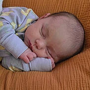 Aubrey is registered to the contest to win money with this photo: baby, sleeping, infant, onesie, blanket, cozy, peaceful, hands, face, head, nap, soft, pastel, child, cute, rest, closeup, skin, person, comfort
