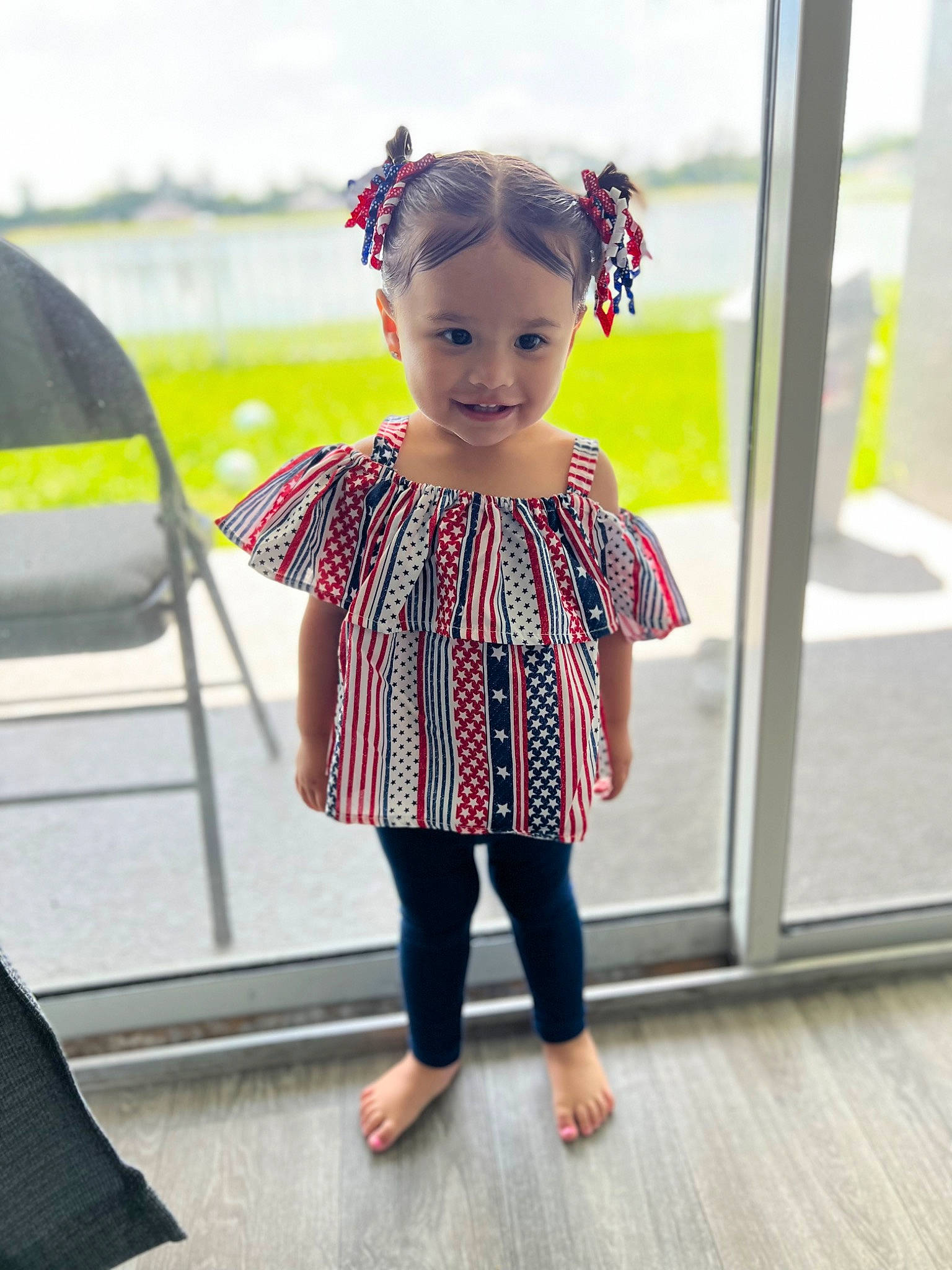 Alaia is registered to the contest to win money with this photo: baby_toddler_clothing, child, eyewear, fashion_accessory, flooring, fun, hair_tie, hairstyle, happy, human_body, joy, magenta, pattern, person, pink, plaid, sleeve, smile, standing, toddler