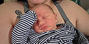 Elliot is registered to the contest to win money with this photo: baby, sleeping, striped_clothing, adult, tattoo, sunflower, closeup, face, arm, skin, comfort, rest, indoor, human, newborn, parent, holding, peaceful, portrait, caring
