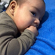 Ethan is registered to the contest to win money with this photo: baby, blue_blanket, child, closeup, cozy, cute, eyes, face, fuzzy, hand, indoor, infant, lying_down, newborn, portrait, resting, skin, sleepwear, soft_texture, toddler