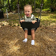 Asa is registered to the contest to win money with this photo: toddler, child, swing, playground, outdoor, happy, smiling, trees, woodchips, greenery, sunlight, clothing, socks, baby, nature, fun, play, park, daylight, joy