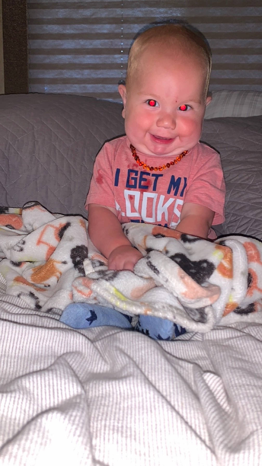 Nolan is registered to the contest to win money with this photo: accessories, baby, bed, bedroom, blanket, clothing, couch, cushion, face, furniture, happy, head, homedecor, indoors, person, photography, portrait, quilt, room, t_shirt