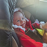 Bella a rejoint le concours — aidez-le/la à gagner de superbes lots ! baby, blanket, car_interior, car_seat, child, cozy, cute, festive, fur_trim, happy, holiday, indoors, infant, portrait, red_clothing, seat, seatbelt, smile, sunlight, warm