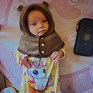 Bella participe au concours pour gagner de l'argent avec cette photo : baby, bear_ears, child, cozy, cute, eyes, face, floor, hand, hood, infant, onesie, pattern, pink, playmat, pouch, shoe, smiling_bear, stars, unicorn