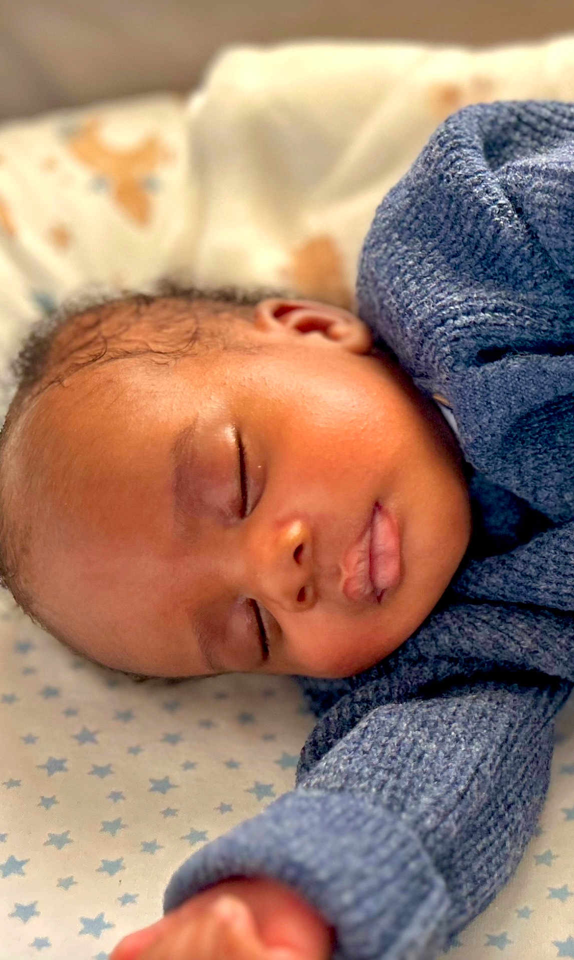 Makai is registered to the contest to win money with this photo: baby, sleeping, infant, closeup, face, arm, knitwear, blue_sweater, blanket, stars, peaceful, rest, soft_light, cute, child, portrait, skin, eyelids, nose, mouth