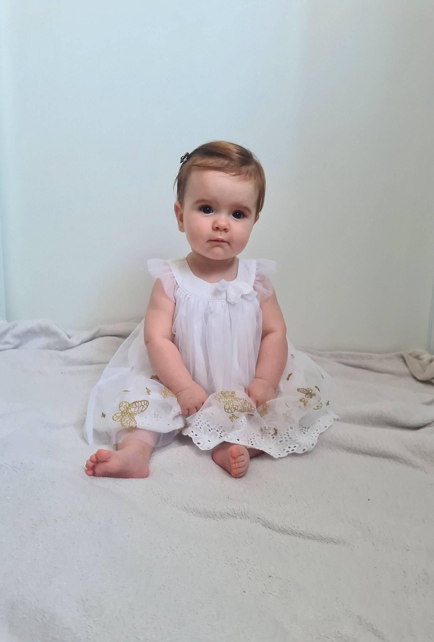 Emma participe au concours pour gagner de l'argent avec cette photo : arm, baby, baby_toddler_clothing, cheek, child, chin, day_dress, dress, embellishment, eye, face, flash_photography, flooring, head, iris, peach, person, sitting, sleeve, toddler