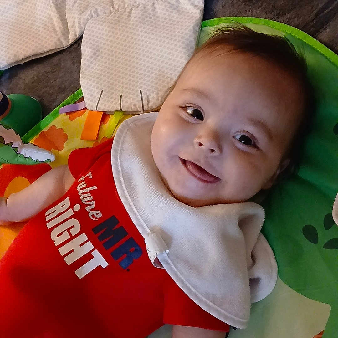 Onyx joined the competition — help win amazing prizes! arm, baby, bib, blanket, child, clothing, colorful, cute, face, hand, happy, indoor, infant, lying_down, onesie, play_mat, skin, smiling, soft_toy, toy