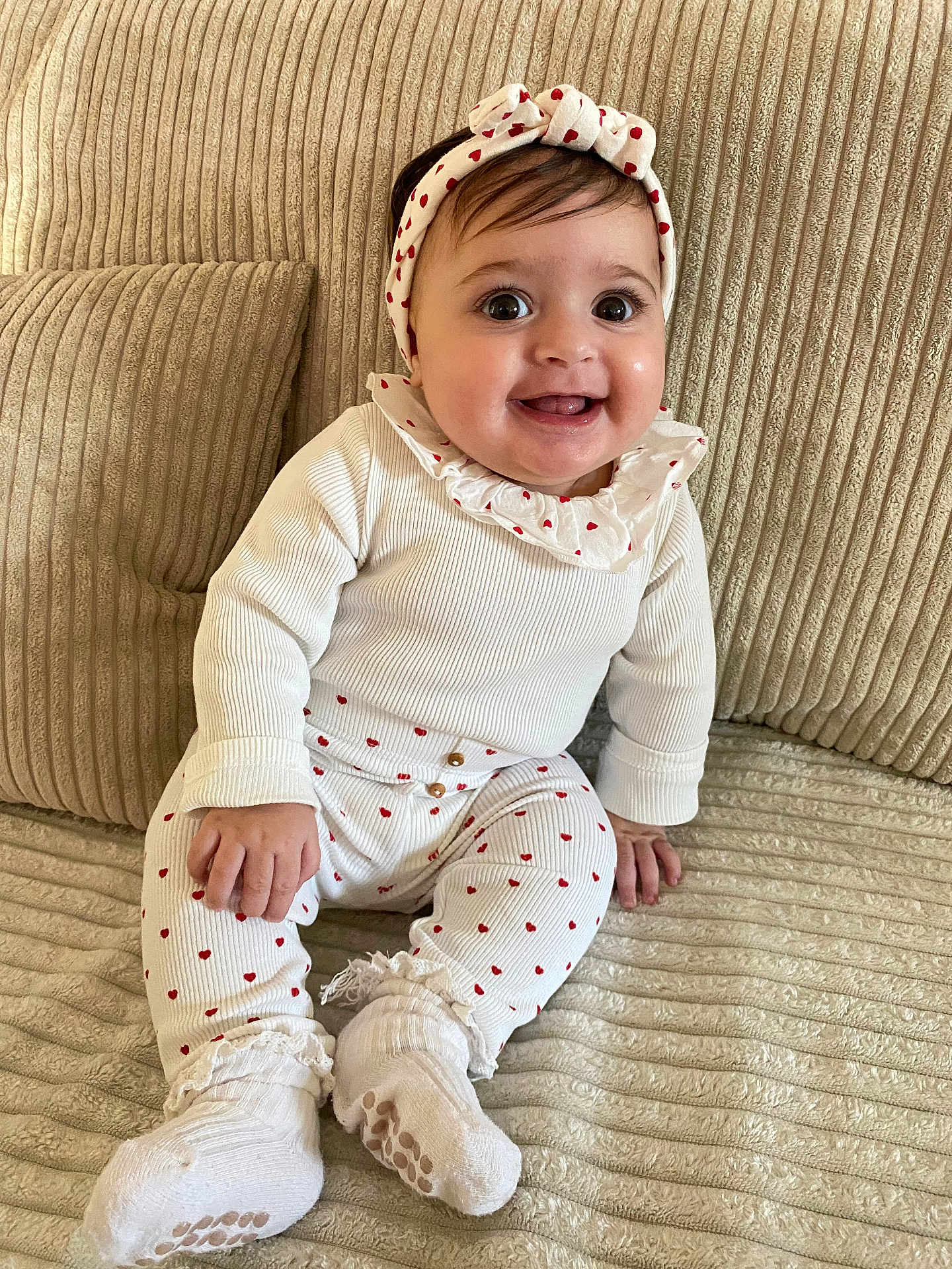 Dina a rejoint le concours — aidez-le/la à gagner de superbes lots ! baby, child, clothing, couch, cozy, cute, fabric, happy, headband, indoor, infant, person, portrait, red_hearts, sitting, smiling, sock, texture, white, young