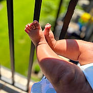 Baba joined the competition — help win amazing prizes! baby, legs, feet, infant, skin, sunlight, shadow, outdoor, railing, blurred_background, child, closeup, toddler, summer, warm, playful, small, human_limb, baby_clothing, soft