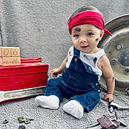 Simon participe au concours pour gagner de l'argent avec cette photo : baby, child, overalls, red_headband, tools, wrench, keys, nuts_and_bolts, wooden_blocks, months, grease_smudges, denim, white_socks, sitting, gray_background, metal_parts, cute, portrait, indoors, hands
