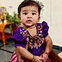 baby, child, infant, portrait, face, hands, purple_dress, pink_skirt, traditional_clothing, bracelets, indoor, person, cute, expression, holding, young, curious, skin, hair, decor