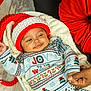 baby, blanket, celebration, child, cozy, cute, family, holding_hands, holiday_sweater, indoor, infant, joy, knit_hat, person, portrait, red_hat, smile, toddler, warmth, winter_clothing