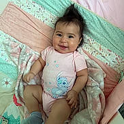 Azalea joined the competition — help win amazing prizes! baby, blanket, child, colorful, cozy, cute, face, happy, head, indoor, infant, lying_down, onesie, person, playful, portrait, quilt, smiling, socks, soft_toys