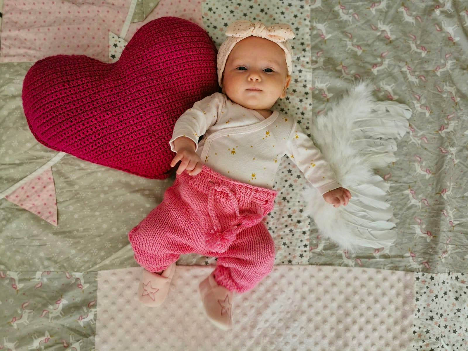 Elidé a rejoint le concours — aidez-le/la à gagner de superbes lots ! baby, baby_products, baby_toddler_clothing, cheek, child, comfort, doll, eye, fawn, linens, magenta, pattern, person, pink, sitting, skin, sleeve, textile, toddler, toy