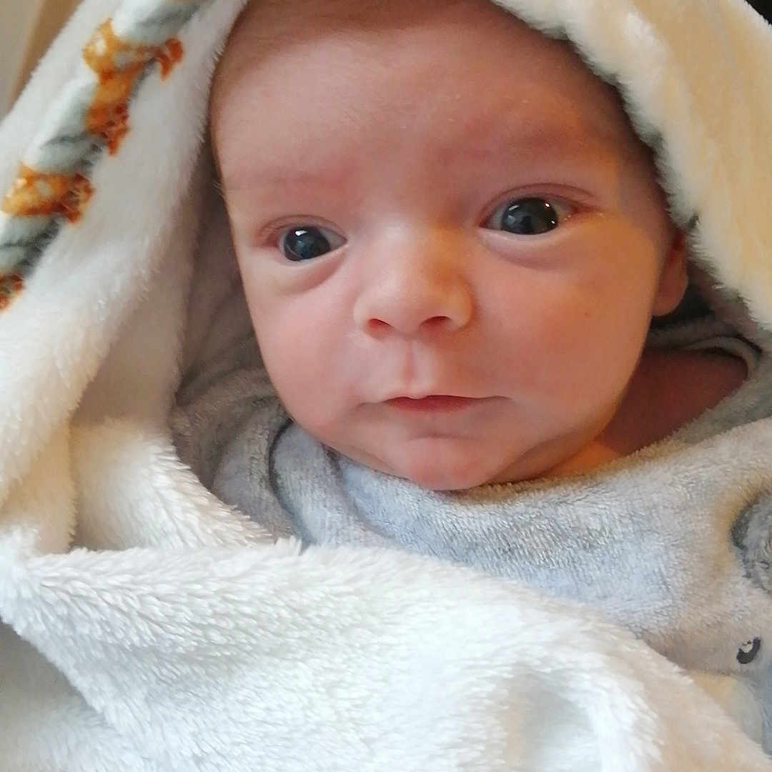 Saïan a rejoint le concours — aidez-le/la à gagner de superbes lots ! baby, bathtowel, blanket, bonnet, clothing, face, fleece, hat, head, hood, hoodie, knitwear, newborn, person, photography, portrait, quilt, sweater, sweatshirt, towel
