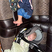 Evan is registered to the contest to win money with this photo: child, baby, toddler, infant, sleeping, car_seat, blanket, couch, leather_sofa, pajamas, bare_feet, patterned_blanket, plaid_cloth, nap, indoor, baby_gear, buckle, head, face, portrait