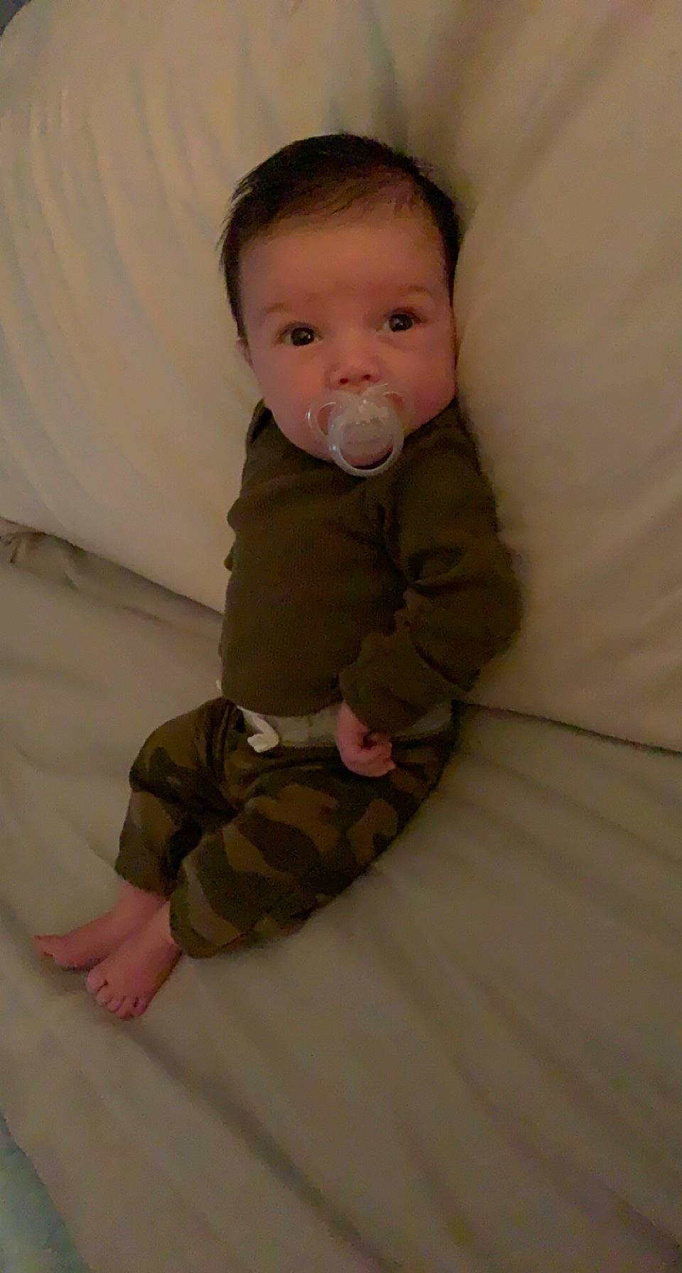 Kolton is registered to the contest to win money with this photo: baby, baby_toddler_clothing, cheek, child, comfort, eye, face, floor, flooring, foot, knee, linens, pattern, person, room, sitting, skin, sleeve, sock, toddler