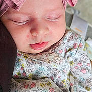 Sage is registered to the contest to win money with this photo: baby, bow, child, closeup, clothing, cute, face, floral, headband, indoors, infant, newborn, peaceful, person, pink, portrait, resting, sleeping, soft, toddler