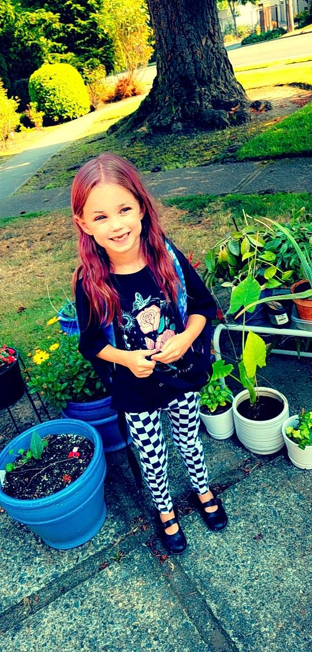 Amber is registered to the contest to win money with this photo: botany, cool, flowerpot, grass, green, hair, hairstyle, happy, joy, leaf, leisure, morning, people_in_nature, person, photograph, plant, shoe, smile, sneakers, summer