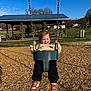 architecture, baby, building, car, clothing, face, footwear, grass, nature, outdoorplayarea, outdoors, pants, park, person, plant, playarea, shelter, shoe, transportation, vehicle