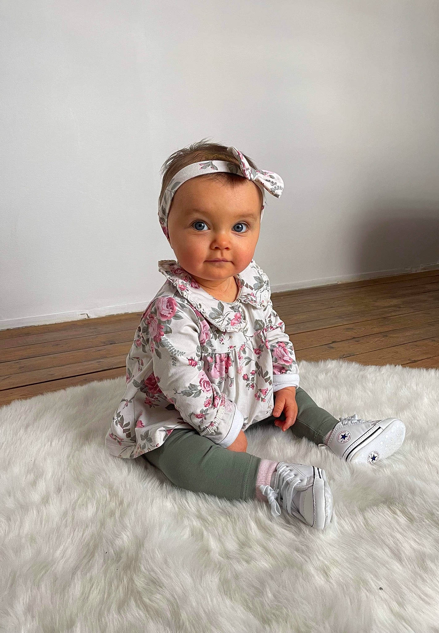 Mila participe au concours pour gagner de l'argent avec cette photo : baby_toddler_clothing, cheek, child, embellishment, fashion_accessory, fashion_design, flash_photography, flooring, grey, hair_accessory, happy, hardwood, headpiece, pattern, person, portrait_photography, sitting, sleeve, toddler, wood