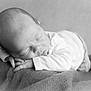 baby, newborn, infant, sleeping_baby, blanket, bed, portrait, black_and_white, monochrome, face, head, hand, fingers, closeup, soft_texture, cozy, peaceful, studio_style, resting, newborn_photography